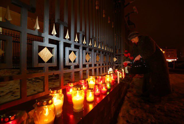 A woman lays flowers in memory of passengers and crew members of Russian military Tu-154 plane, which crashed into the Black Sea, at the Russian embassy in Minsk, Belarus December 25, 2016.  REUTERS/Vasily Fedosenko
