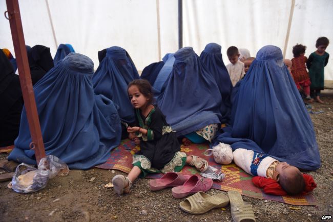 Afghan refugee women sit with their children after returning to Afghanistan from Pakistan, at the UNHCR camp on the outskirts of Kabul in September 2016.